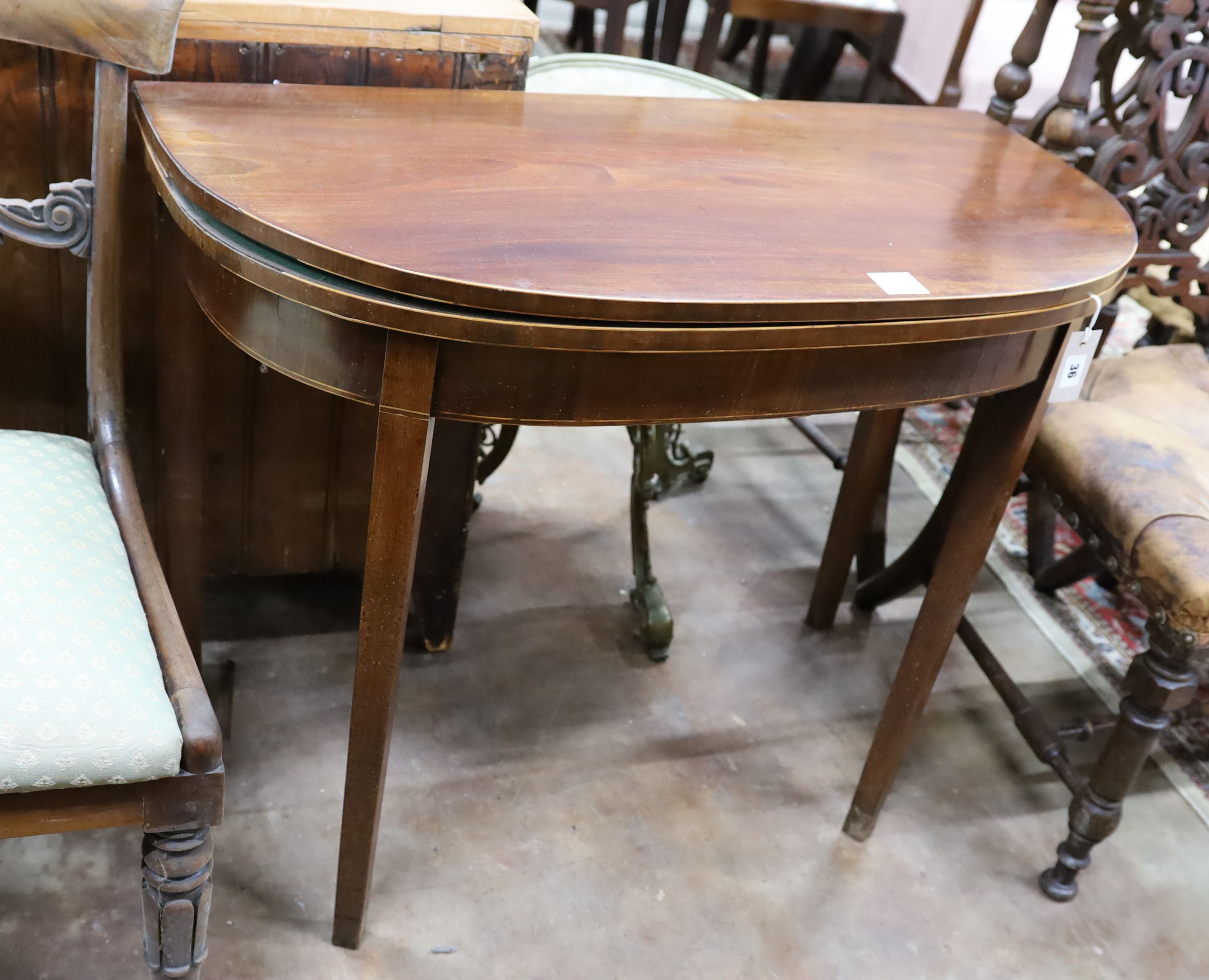 A George III inlaid mahogany D shaped folding card table, width 91cm, depth 45cm, height 74cm